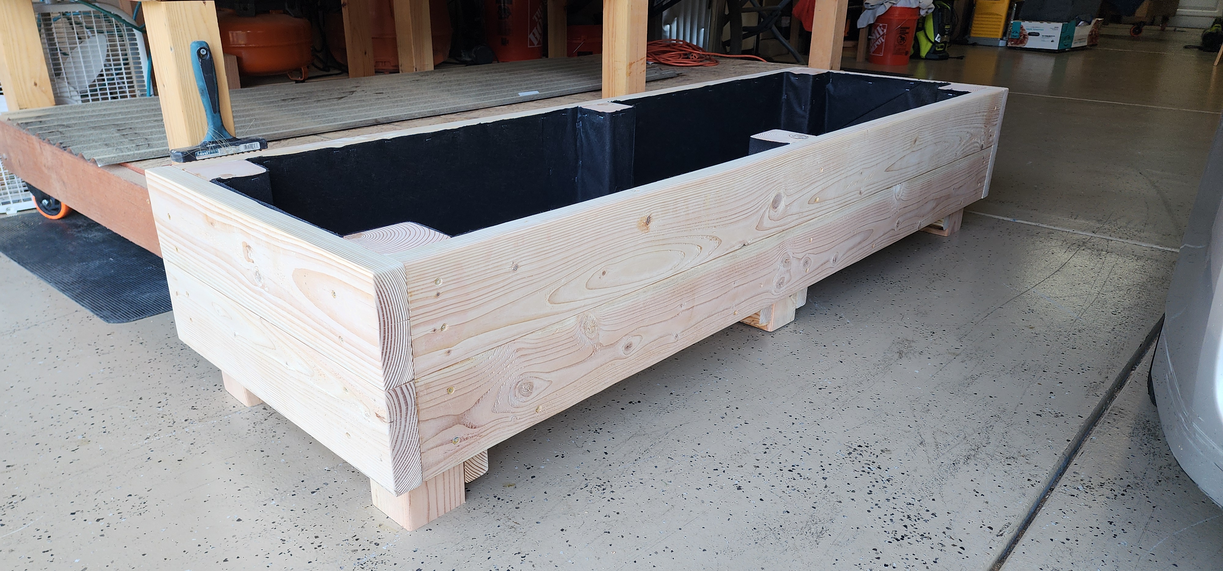Low-profile white six-foot planter on patio pavers